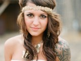 a draped strapless wedding dress with a statement necklace and a black ink tattoo on the shoulder
