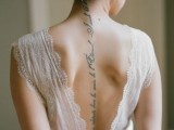 a gorgeously chic fitting wedding dress with thick straps and a cutout back that shows off the bride’s tattoo