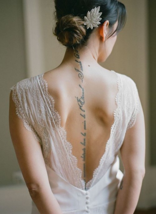 a gorgeously chic fitting wedding dress with thick straps and a cutout back that shows off the bride's tattoo