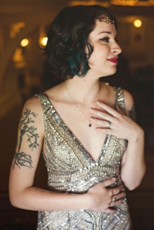 a fully embellished silver art deco fitting wedding dress with a deep V-neckline and no sleeves to show off the bride's tattoo on the shoulder