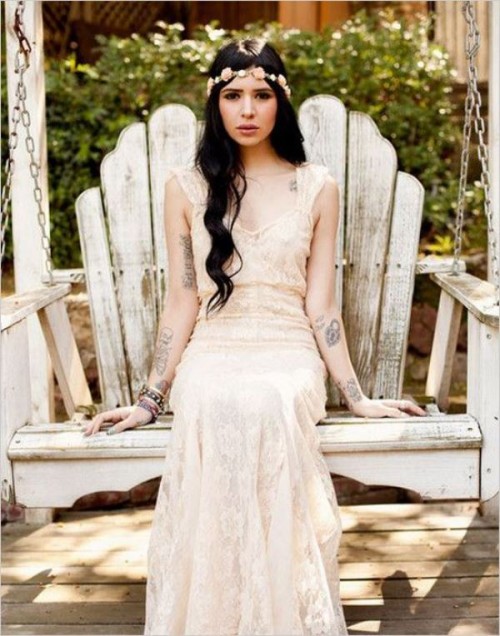 a lace semi-fitting wedding dress with thick straps and no sleeves to show off the bride's tattoos at their best