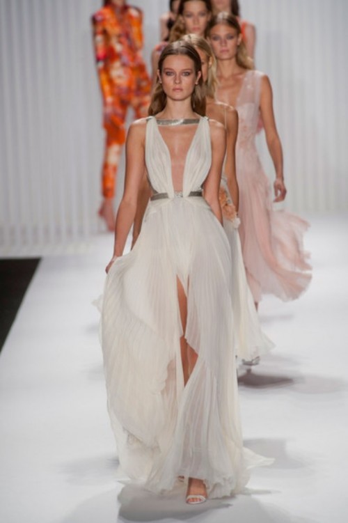 a sleeveless Grecian-style full pleated wedding dress with a front slit and a deep plunging neckline plus horizontal silver straps