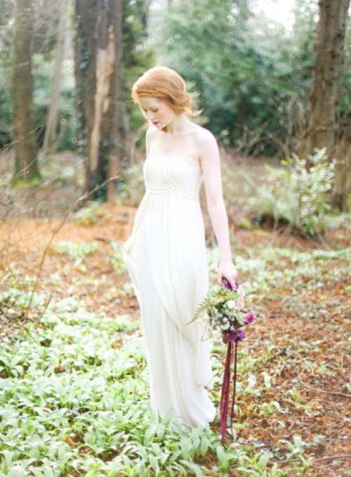 a strapless draped and ruffled A-line wedding dress with a draped bodice and a pleated skirt
