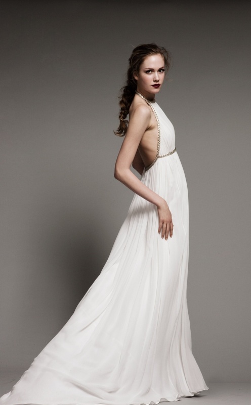 a Grecian A-line wedding dress with a halter neckline, an open back and detailing on the bodice and waist