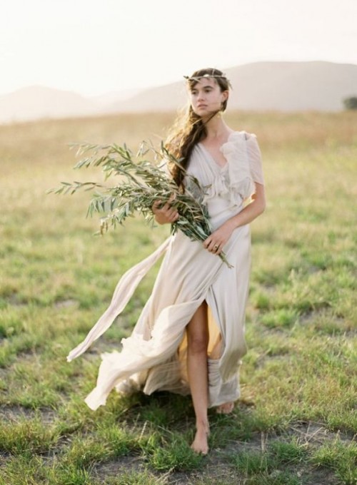 a neutral draped Grecian wedding dress with short sleeves, a V-neckline and a front slit plus a train
