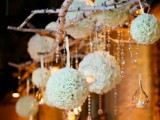 an overhead floral installation of brich branches, crystals hanging down, clear candleholders and some white floral orbs is wow