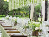 garlands of green and white blooms hanging down from overhead are a chic and cool idea to enliven your reception