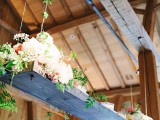 a simple rustic installation of a board and some neutral blooms and greenery for a cozy farmhouse reception