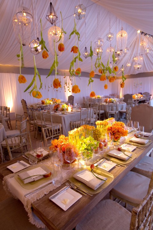 some orange tulips plus refined crystal chandeliers hanging down from above look super cool and chic