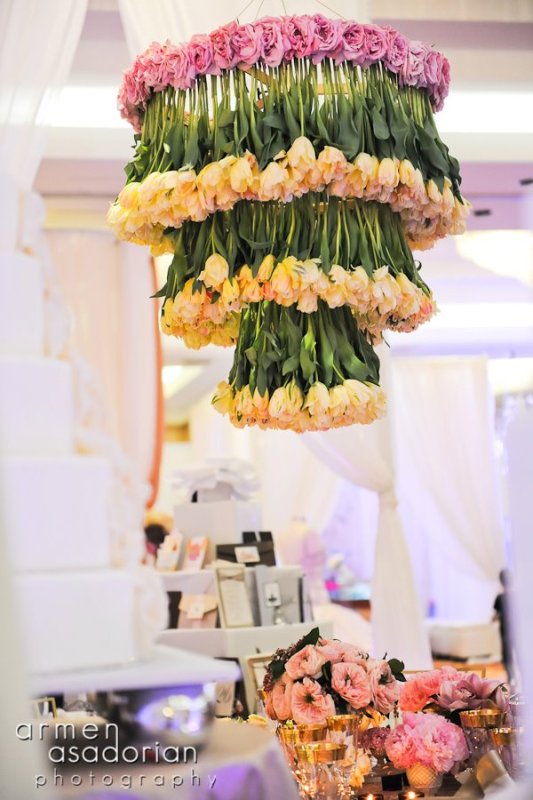 A fantastic floral chandelier of neutral tulips and pink roses on top is a chic and bold idea