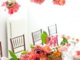 some pink peonies hanging down from above echo with the centerpieces and look very cool
