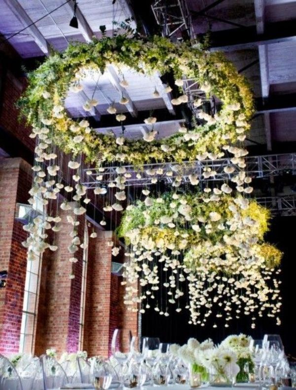 Super lush and oversized green chandeliers with white blooms hanging down are an amazing reception decoration