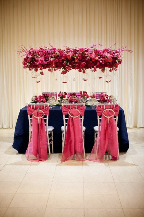 a luxurious red and pink overhead pink decoration with bulbs and petals in them is a super bright touch to your reception