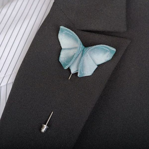 An ice blue paper butterfly boutonniere is a lovely accessory for a winter groom's look