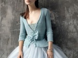 an ice blue top and a matching cardigan with a tulle skirt make up a chic and beautiful winter bridal look