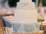 an ice blue and white patterned and textural wedding cake is a nice fit for a refined vintage wedding in winter