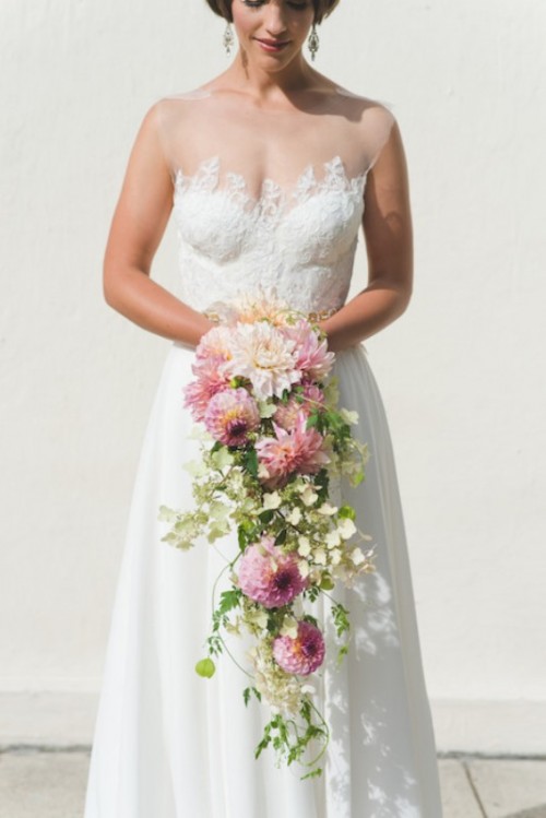 a lace A-line wedding dress with an illusion neckline and no sleeves is a chic piece to highlight all your curves