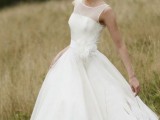 a retro-inspired A-line midi wedding dress with an illusion neckline and a sash is a cool and cute idea