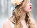 an oversized peachy fabric bloom, pale leaves and some ribbons is a subtle and chic touch to your bridal look