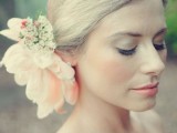 an oversized blush fabric flower headpiece plus some small white blooms for a lovely and stylish spring or summer bridal look
