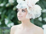 an oversized blush and white fabric bloom headpiece is a gorgeous statement for a bridal look, with a bit of fun