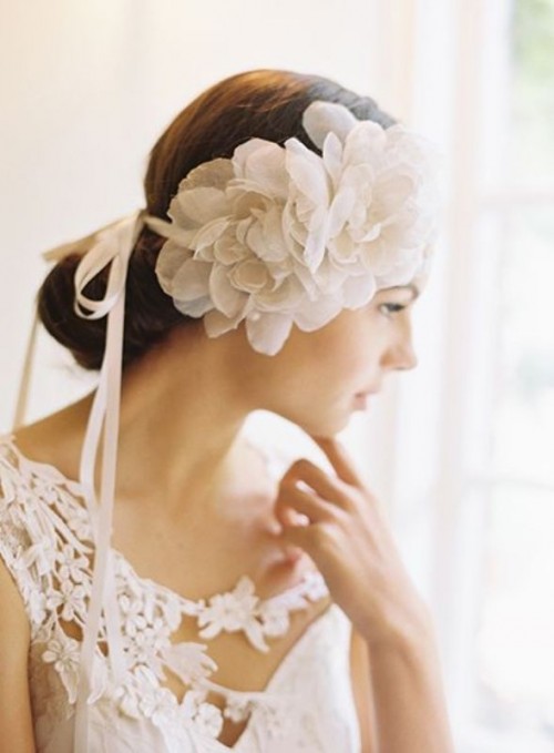 a wedding headpiece with white fabric blooms and ribbons is a lovely idea to add a chic and delicate feminine touch to the look