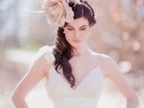 an oversized fabric flower headpiece with feathers will give a whimsical and chic touch to your bridal look making it a bit vintage
