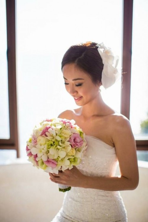 an oversized white flower headpiece on one side is a delicate and chic wedding accessory for a vintage-inspired bride