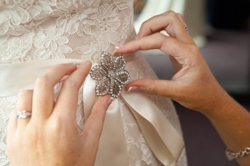 a vintage brooch accenting a wedding sash is a cool accessory and your 'something old' at the wedding
