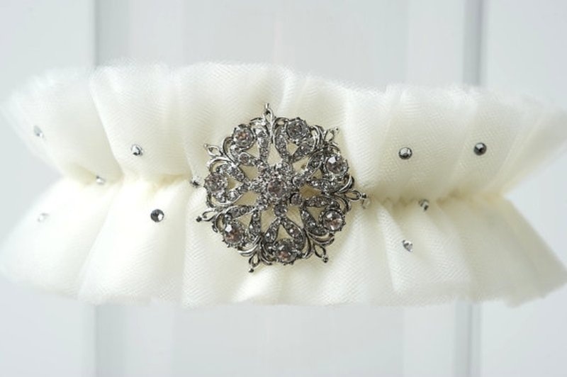 a tulle garter decorated with rhinestones and a vintage brooch is a lovely wedding accessory to rock