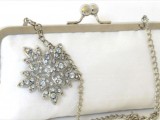 a white vintage wedding pouch with a vintage brooch is a lovely accessory for a bride