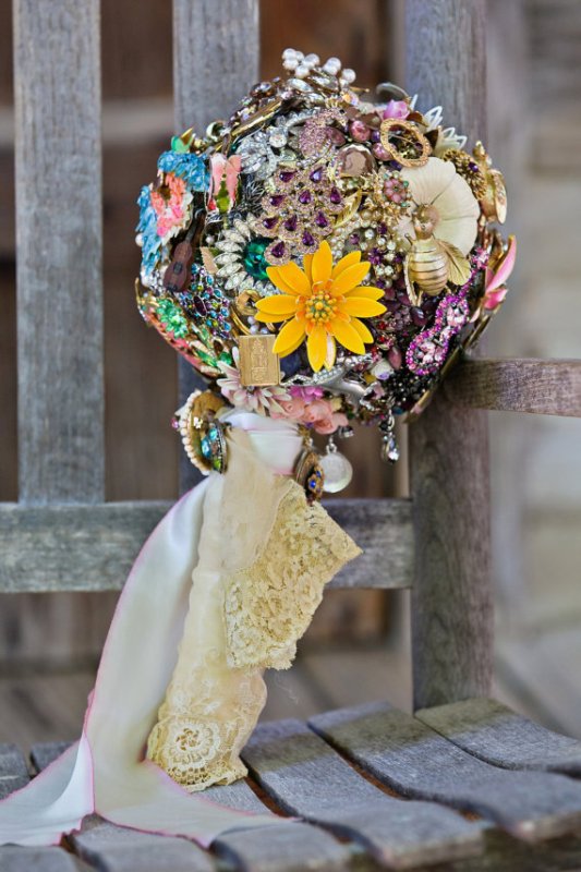 a beautiful and bold vintage brooch wedding bouquet of colorful and bold items and with ribbons is amazing for a wedding