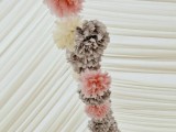 a garland of pink, white and grey paper pompoms lining up the ceiling of the tent is a very cozy and cool idea, add chandeliers for more light