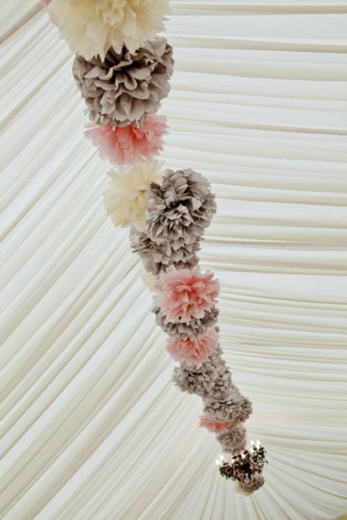 a garland of pink, white and grey paper pompoms lining up the ceiling of the tent is a very cozy and cool idea, add chandeliers for more light