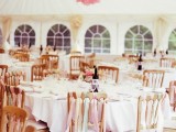 a white and pink paper pompom decoration and matching ribbons on the chairs for a romantic feel and a chic look