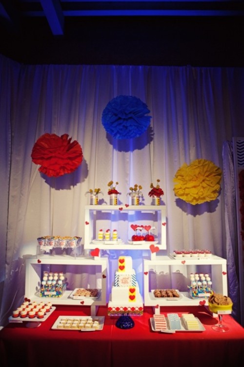 colorful paper pompoms over the dessert table accent it and add color to it making it fun