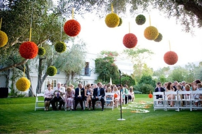 Large colorful paper pompoms over the reception space make it bright, bold and cool