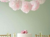 light pink paper pompom garlands over the table to match blusha nd light pink wedding decor and accent the tablescape