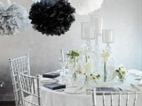 grey, white and black paper pompoms over the table perfectly finish the monochromatic space decor
