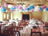 colorful blue, purple and white paper pompom garlands add color and fun to the barn wedding reception space