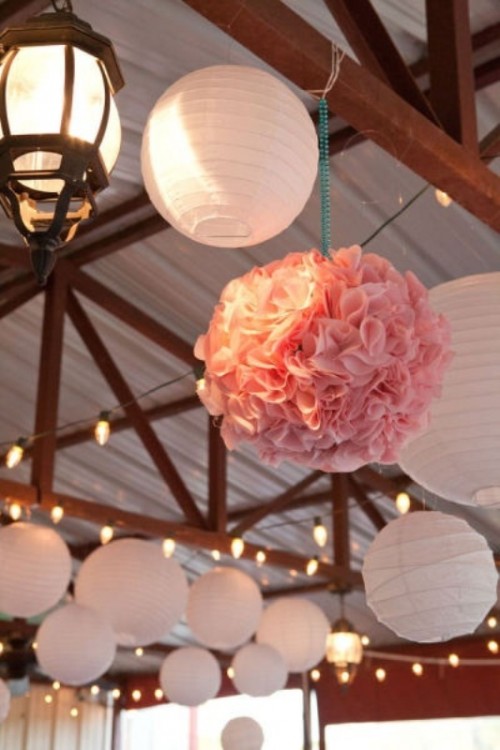white paper lamps and pink paper pompoms plus lights for simple and cozy wedding reception decor