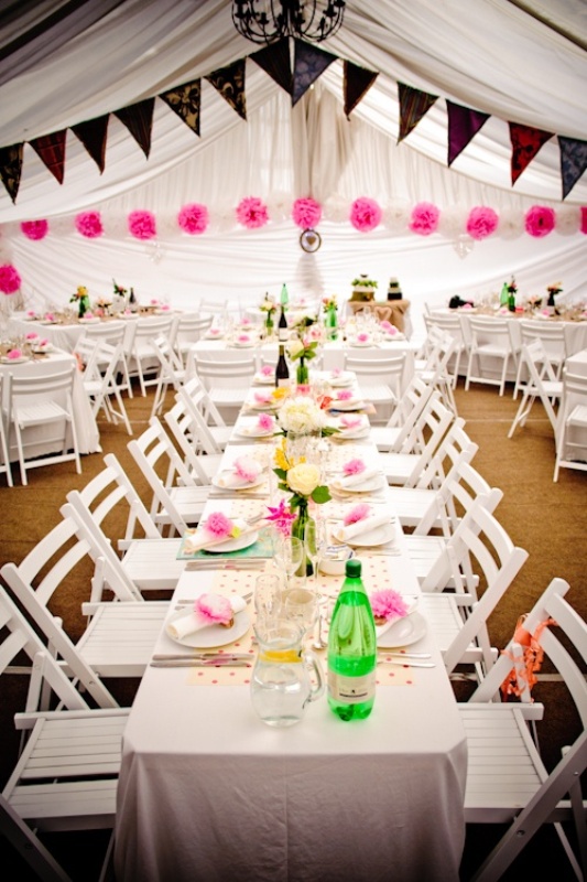 Colorful lace paper buntings and hot pink paper pompom garlands make the reception space look bold and fun