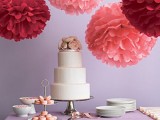 oversized red and pink paper pompoms over the dessert table look very cool, fresh and bold