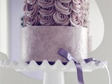 a dusty pink wedding cake with a rose tier and a lilac bow for a romantic wedding