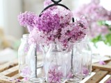 bottles with lilac compose a nice wedding centerpiece for a spring or summer wedding