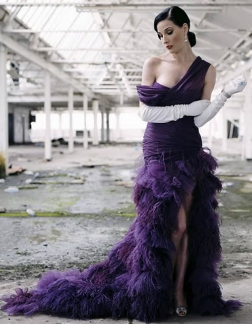 a deep purple one shoulder with a draped bodice and a feather skirt with a train plus white gloves