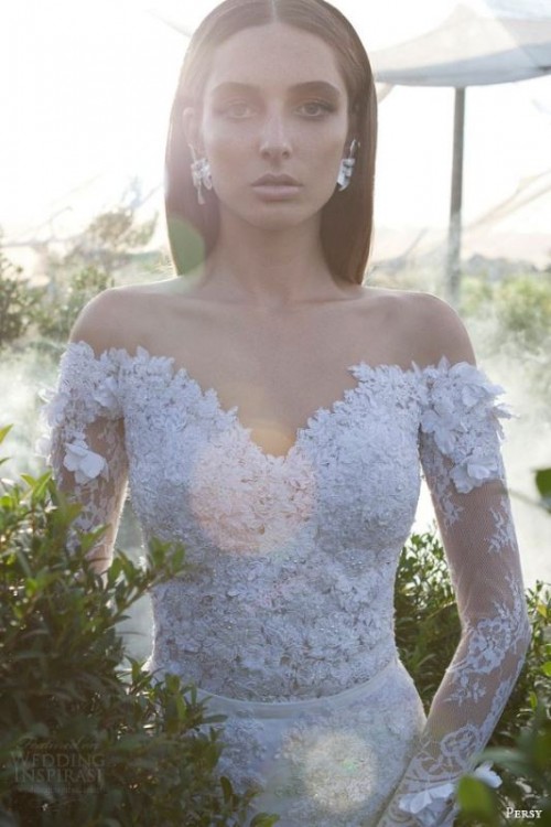 a sophisticated lace embellished off the shoulder wedding dress with long sleeves and matching earrings for a stunning and refined bridal look
