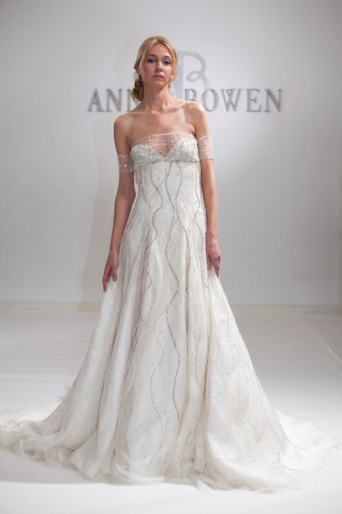 an embellished A-line off the shoulder wedding dress with a depe neckline and an embellished sheer detail on the neckline is wow