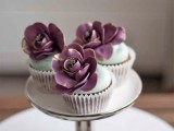 chic and delicious wedding cupcakes done with mint icing and large purple sugar blooms with gold edges are amazing for a spring or summer wedding