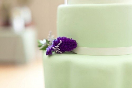 a mint wedding cake with a purple bloom is a stylish and bold wedding dessert is super cool and fun